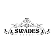 The black and white logo for Swades Foods, featuring an ornate decorative crest above the brand name in a bold serif font, with 'FOODS' written in smaller capital letters underneath, all on a solid white background.